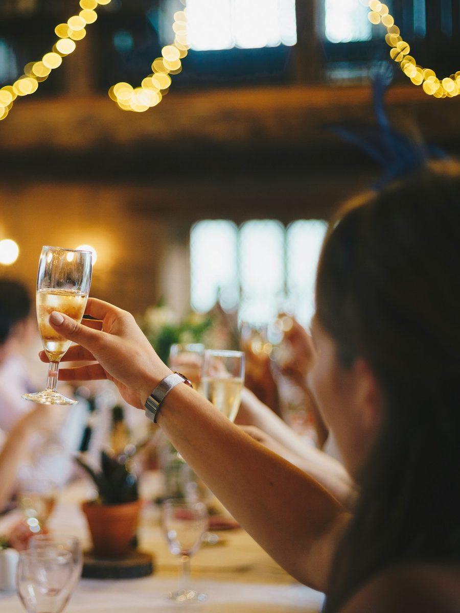 Invités portant un toast sous des guirlandes lumineuses